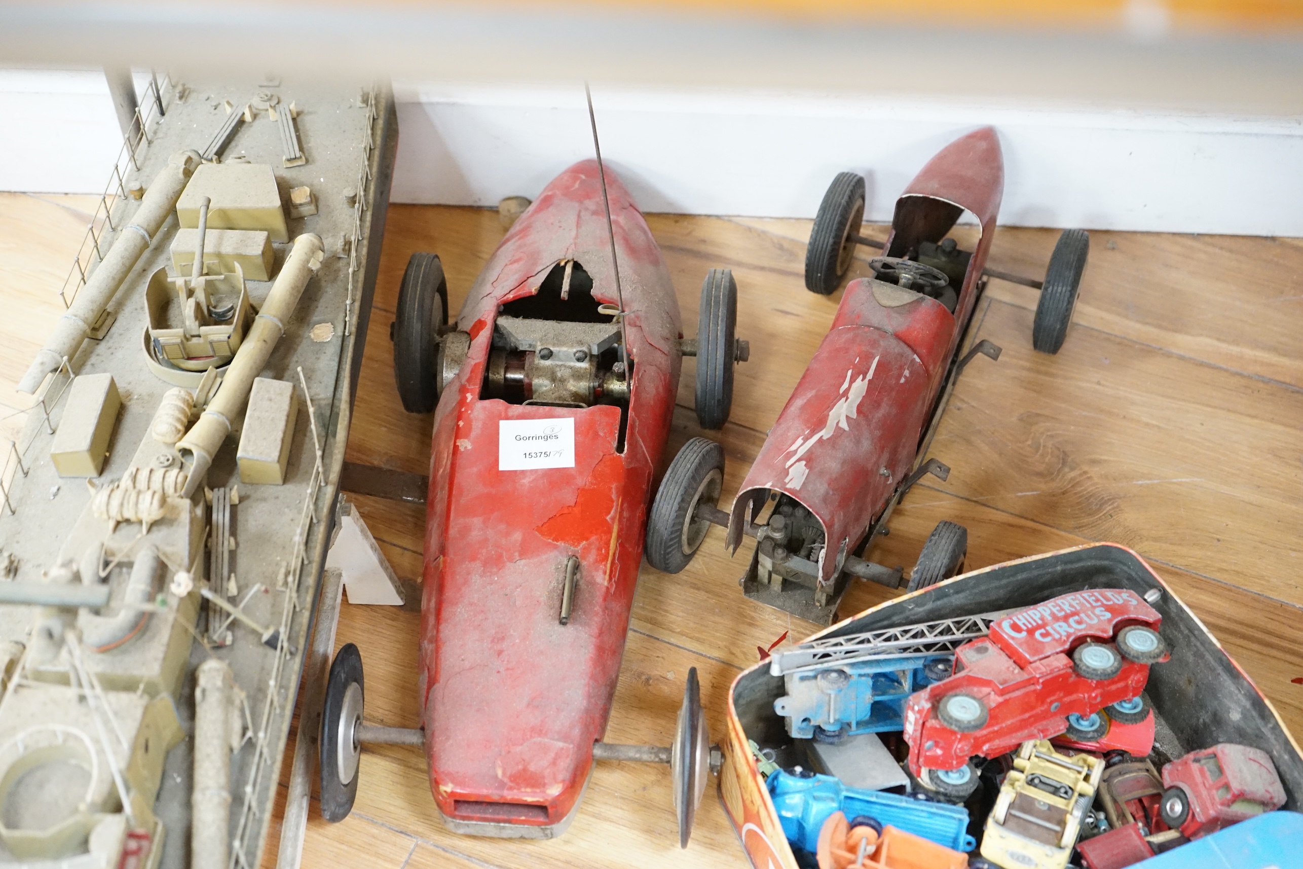 Two tinplate model racing cars, a model aeroplane, battleship and other various cars. Condition - poor